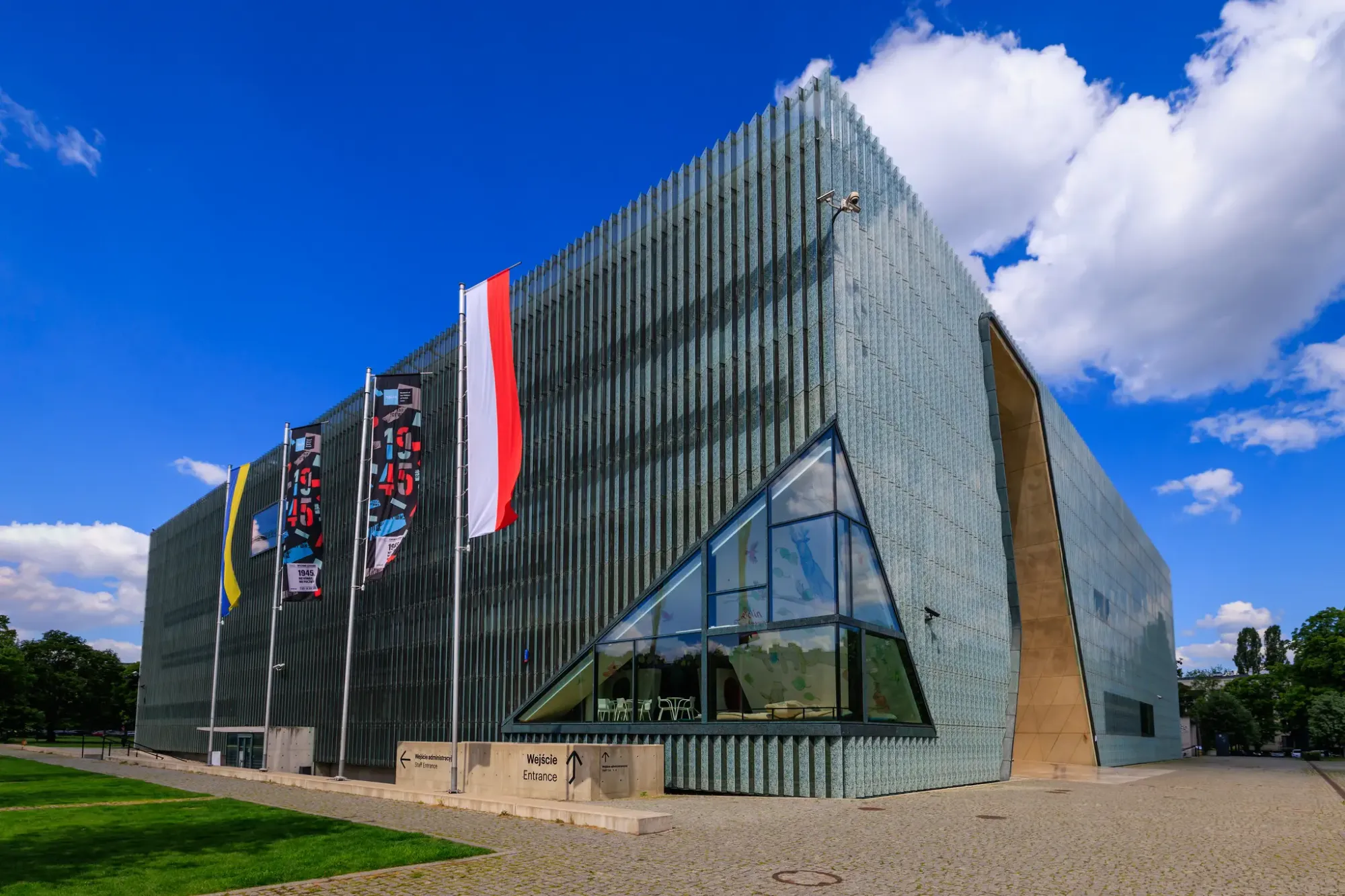 The building’s striking glass façade and golden interior passage evoke both continuity and fracture on the site of the former Warsaw Ghetto.